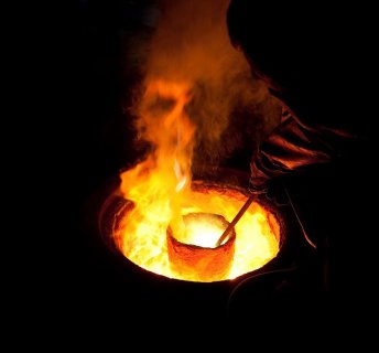 Metal being melted in a ladle, ready for casting