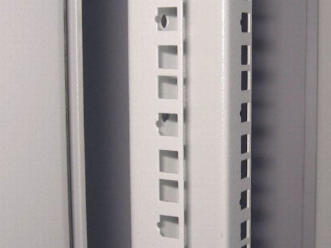 Close up of vertical rail in an enclosure showing mounting holes